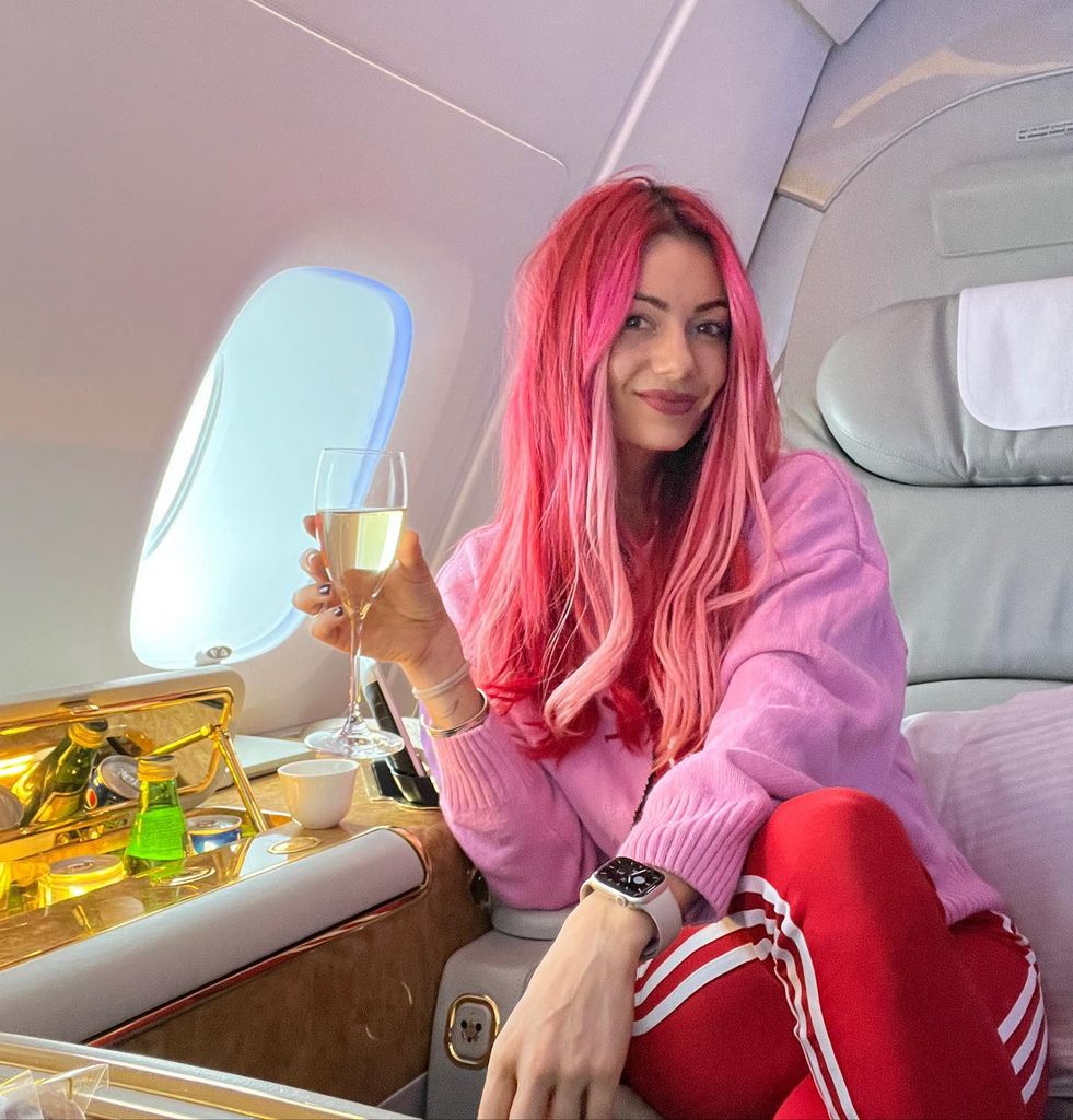 Dianne with pink strands through her red hair on plane