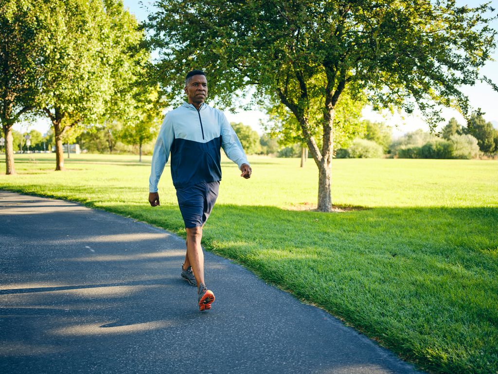 An older man strolling through the park for exercise