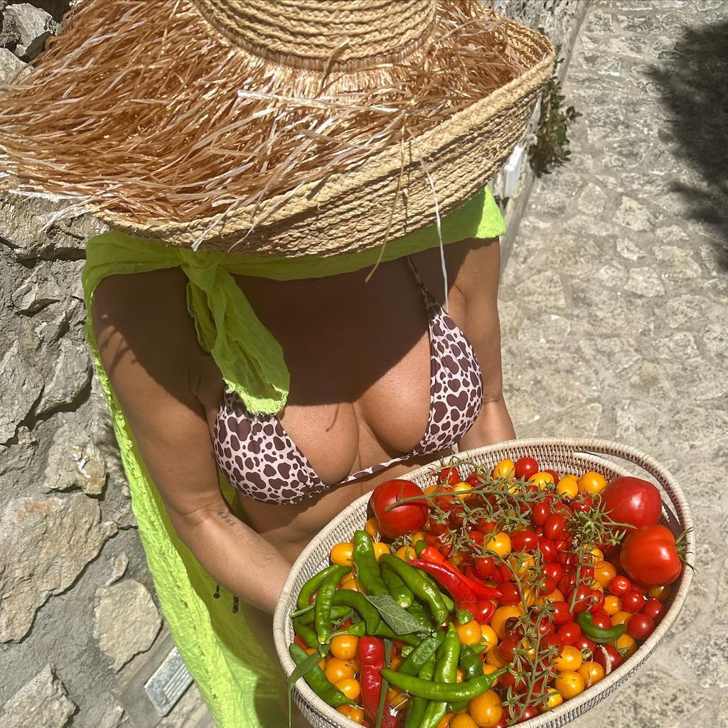 Heidi Klum in a leopard print bikini holding a punnet of tomatoes