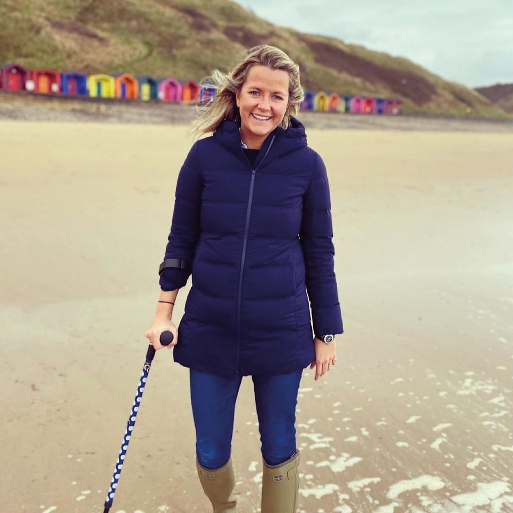 Woman on the beach using a crutch