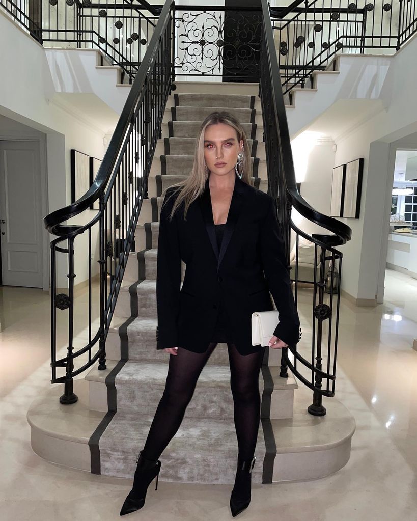Perrie standing in hallway with stairs