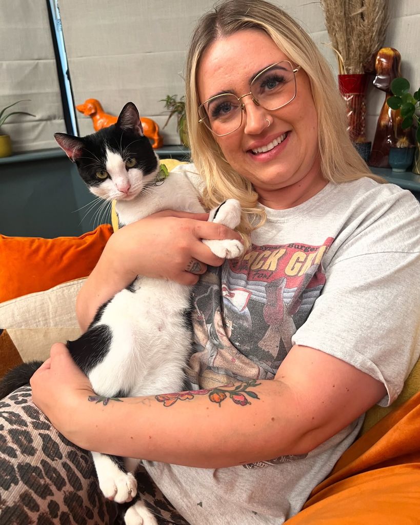 woman cuddling cat on sofa 