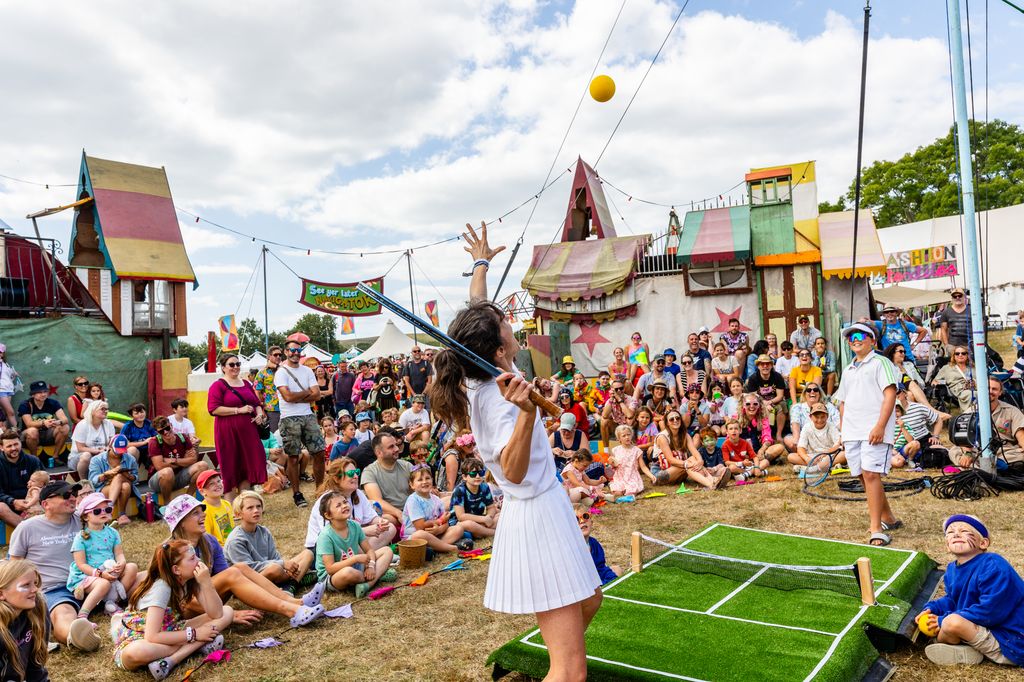 Two people playing tennis on a small table in front of a crowd