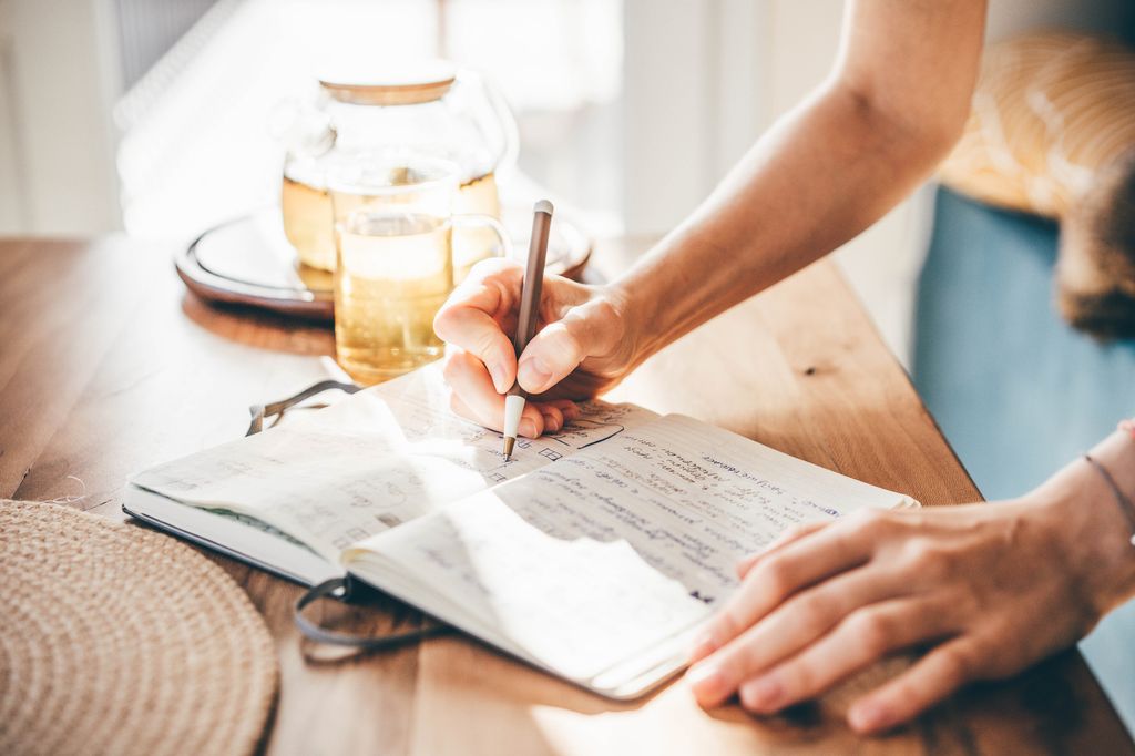 Woman writes in notebook.