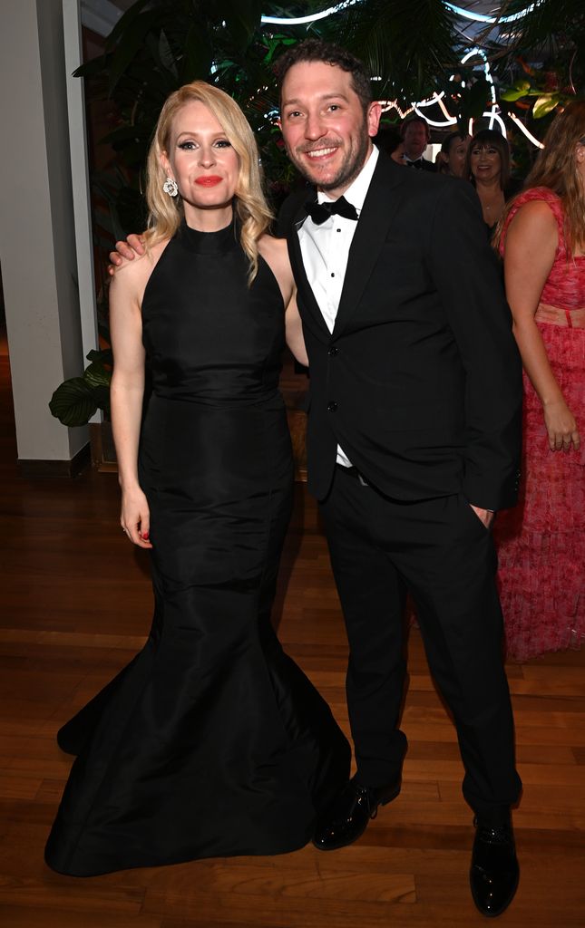 Lucy Beaumont in a black halterneck dress standing with Jon Richardson in a black tuxedo