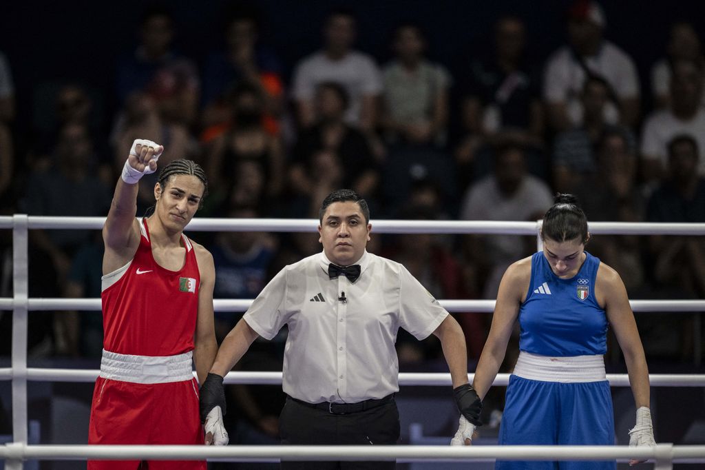 A referee declaring Imane Khelif victorious over Angela Carini