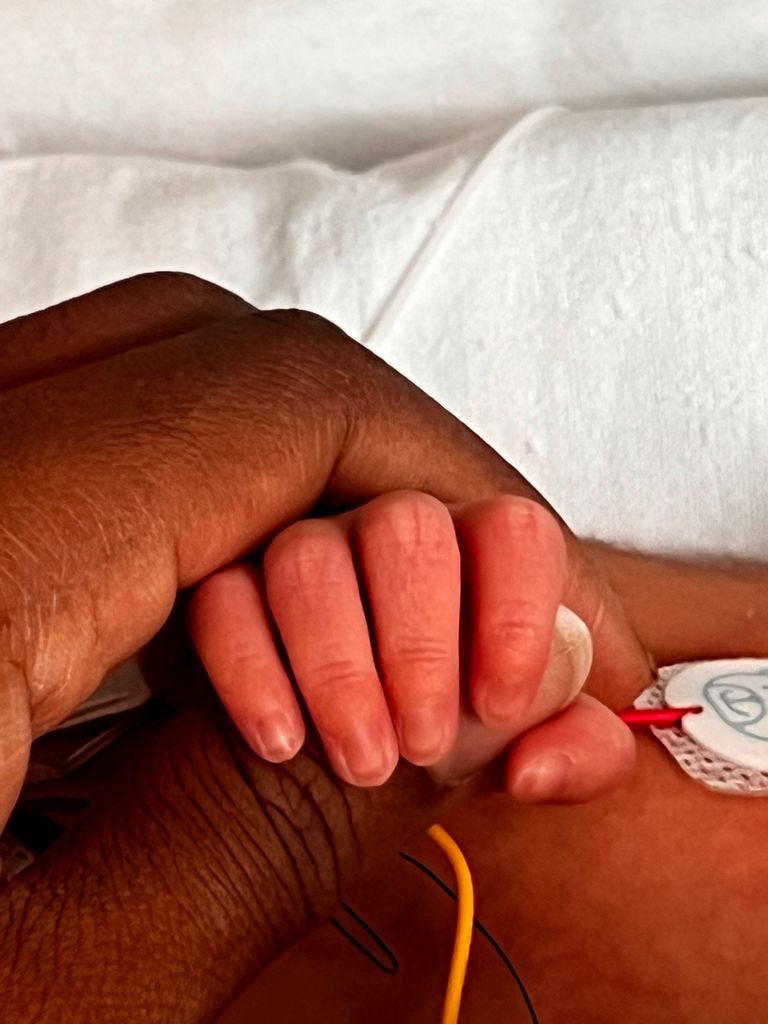 mother holding tiny baby hand