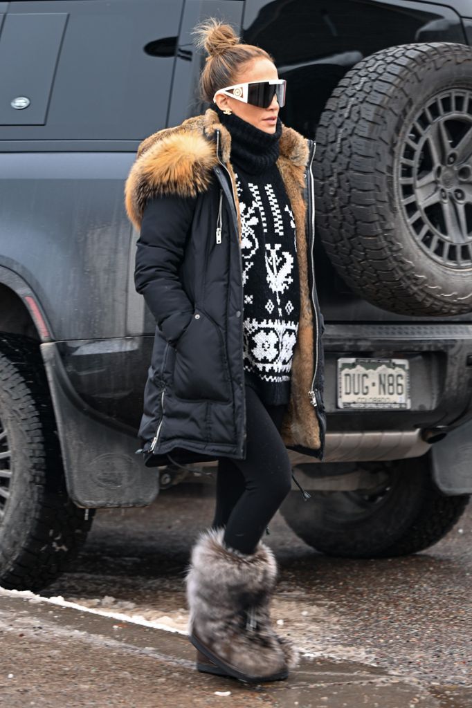 Jennifer Lopez in jumper, coat and snow boots