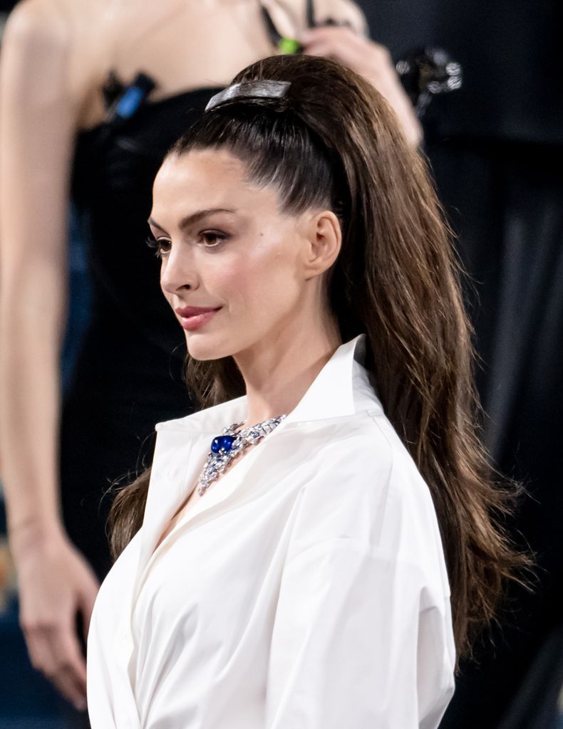 anne hathaway in white shirt and striped shirt at 2025 met gala
