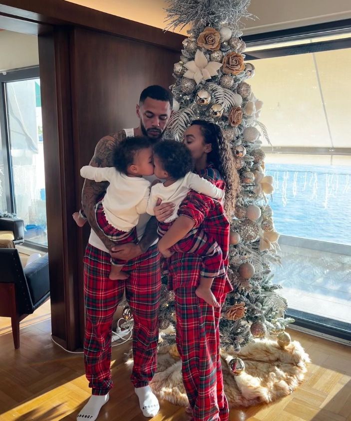 Leigh-Anne Pinnock and Andre Gray holding twin children by a Christmas tree