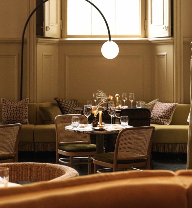 olive-toned decor table chairs and banquette seating in restaurant
