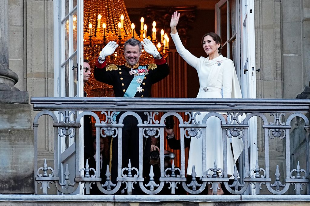 Frederik X and Queen Mary of Denmark wave from the balcony of Amalienborg