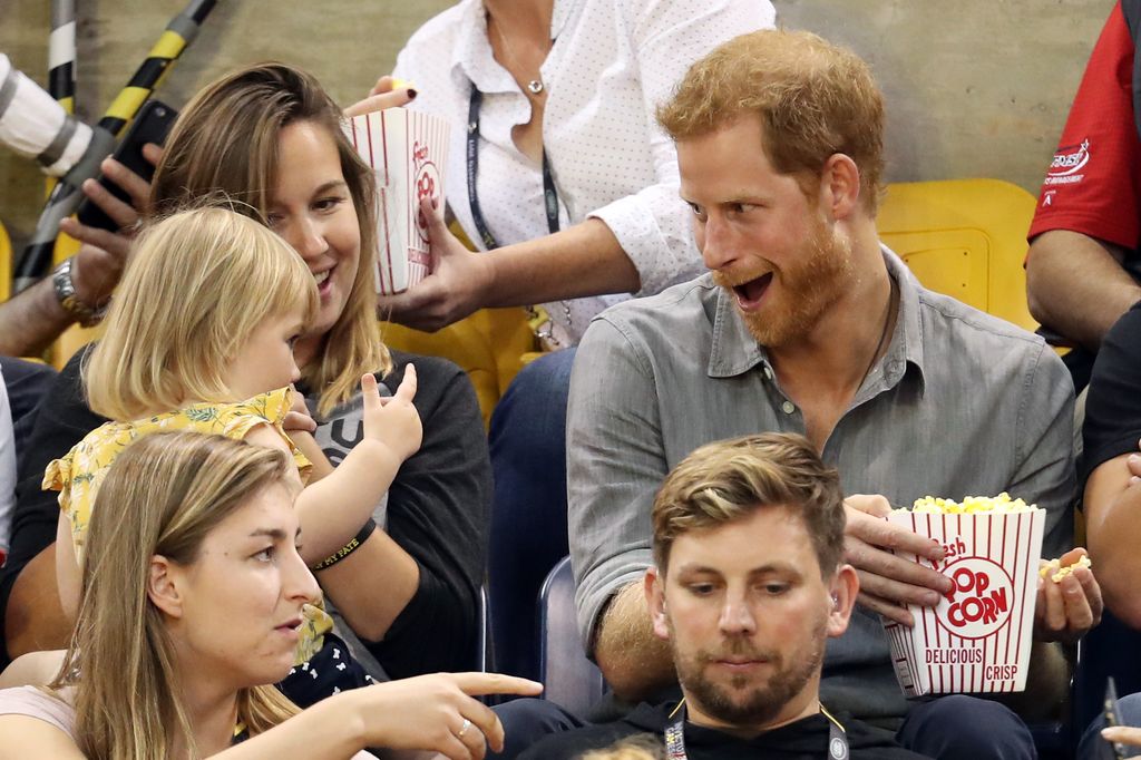 Prince Harry laughs after a little girl takes his popcorn