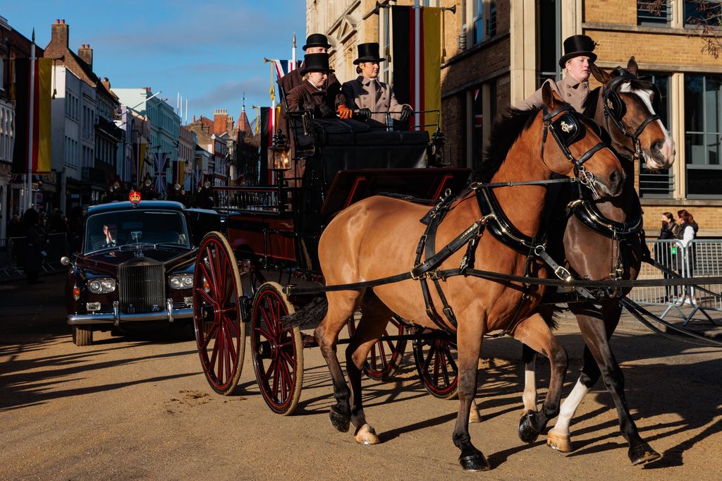 A carriage and royal vehicles pass along the High Street during a rehearsal for a carriage ride 