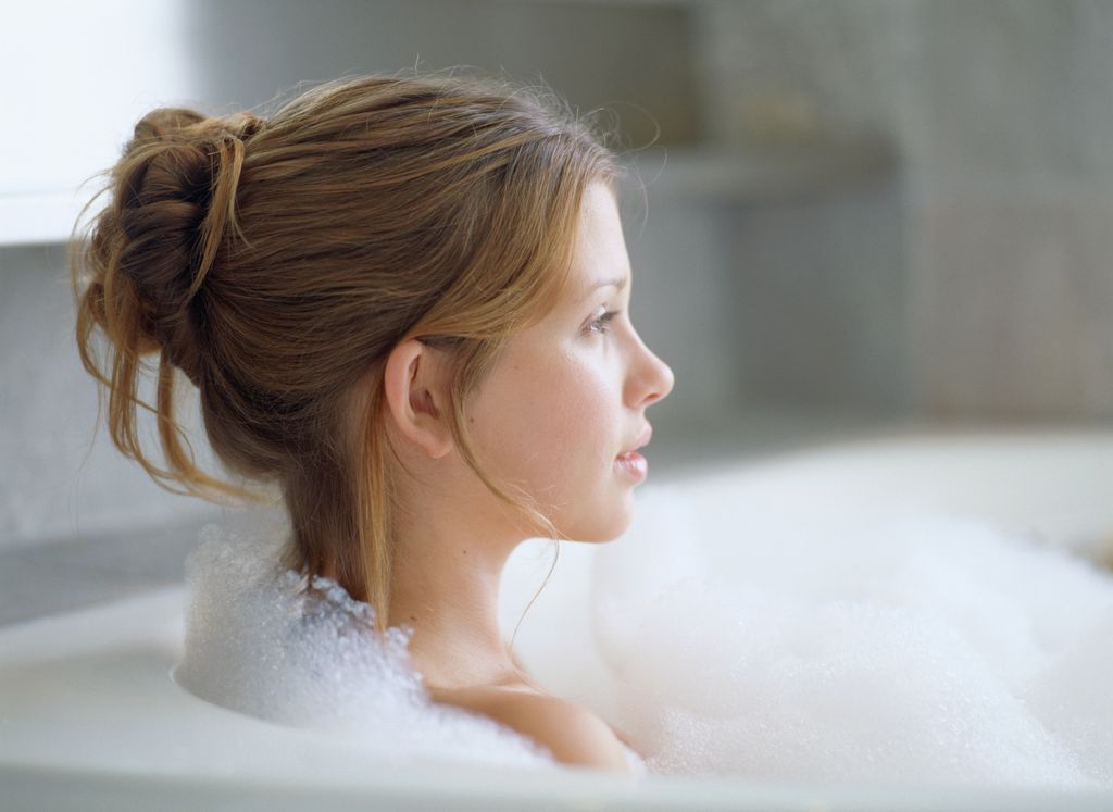 Low wispy bun with face-framing tendrils