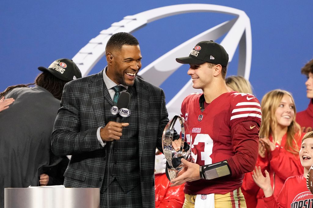 Brock Purdy #13 of the San Francisco 49ers is interviewed by Michael Strahan while holding the George Halas Trophy after defeating the Detroit Lions 34-31 in the NFC Championship Game at Levi's Stadium on January 28, 2024 in Santa Clara, California