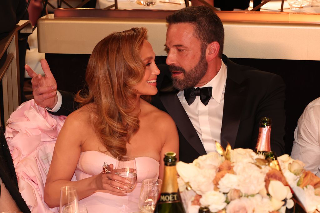 Jennifer Lopez and Ben Affleck drinking wine at a dinner table
