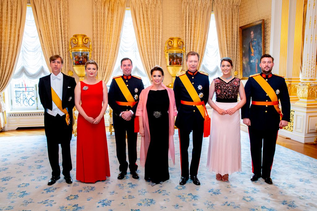 royal family members in grand room wearing sashes