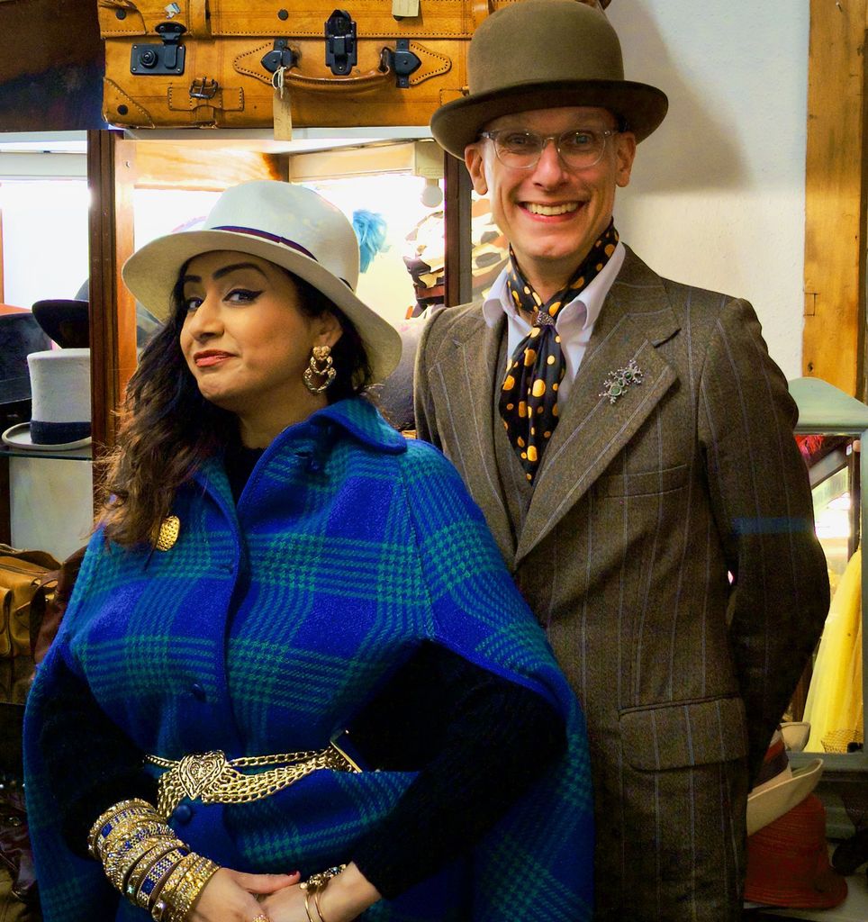 Woman in blue coat, man in suit smiling at camera