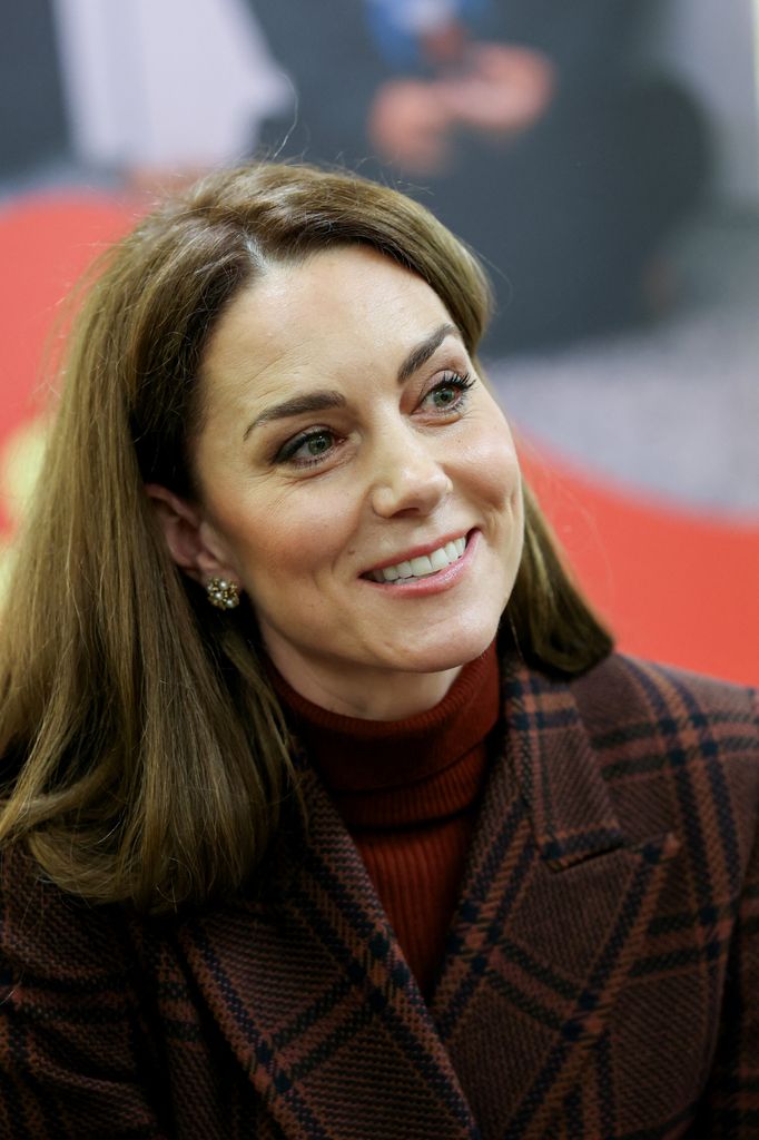 Kate Middleton smiling in checked coat