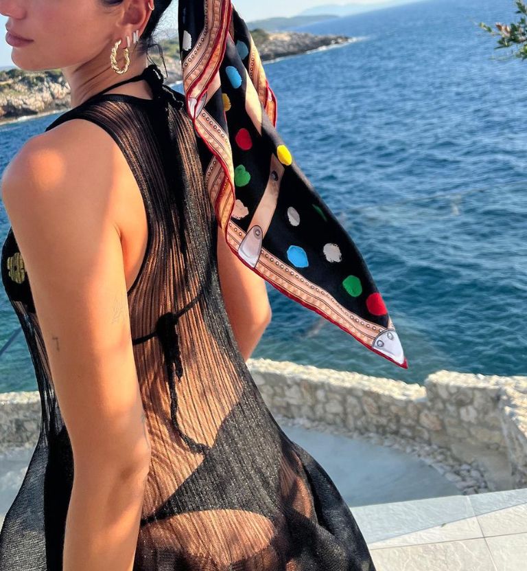 Dua Lipa in a black bikini and polka-dot headscarf