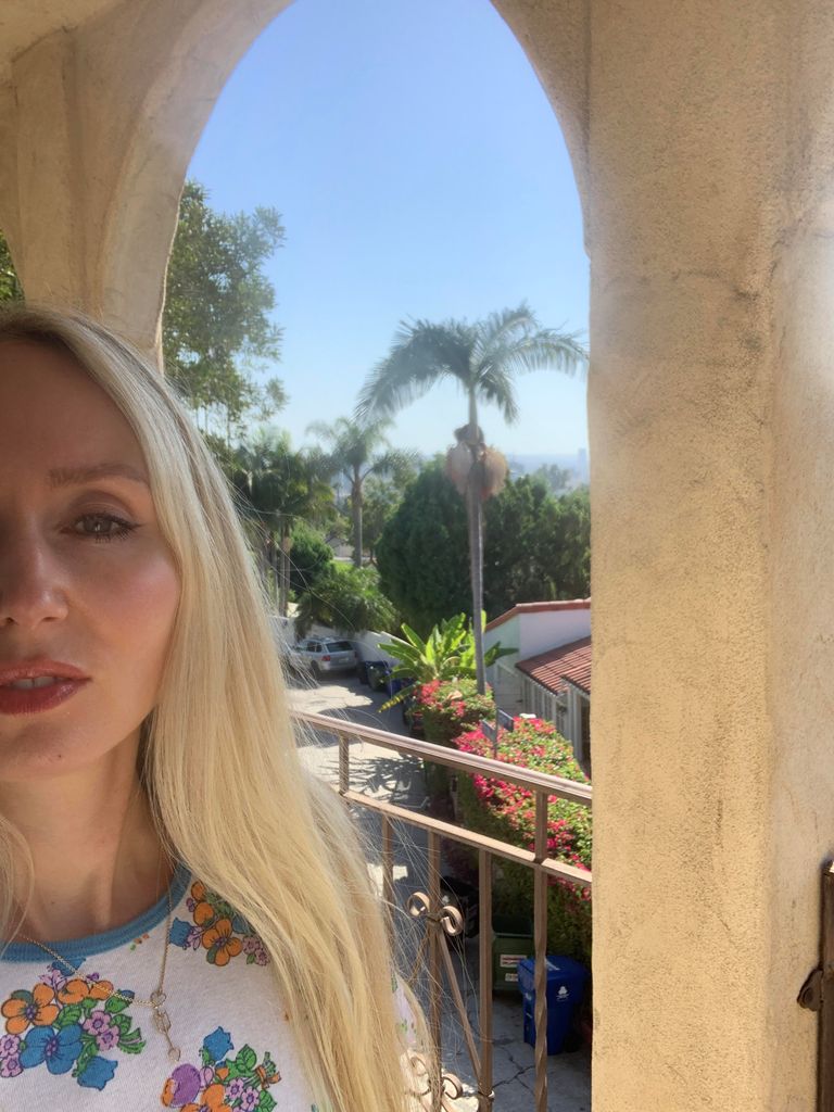 Cassie on holiday in LA with a palm tree in the background