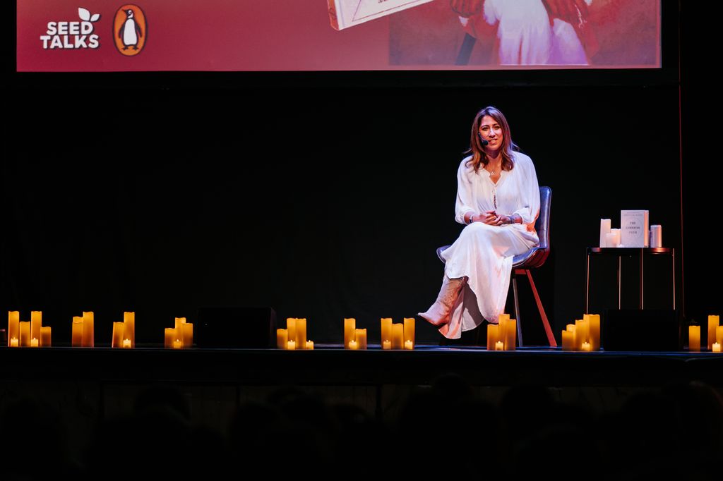 Kirsty on a stage surrounded by candles 