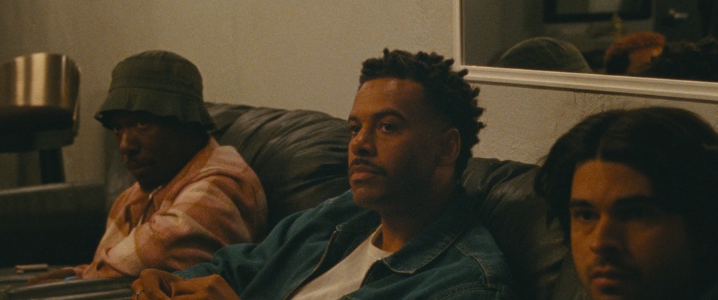 three men sitting on sofa