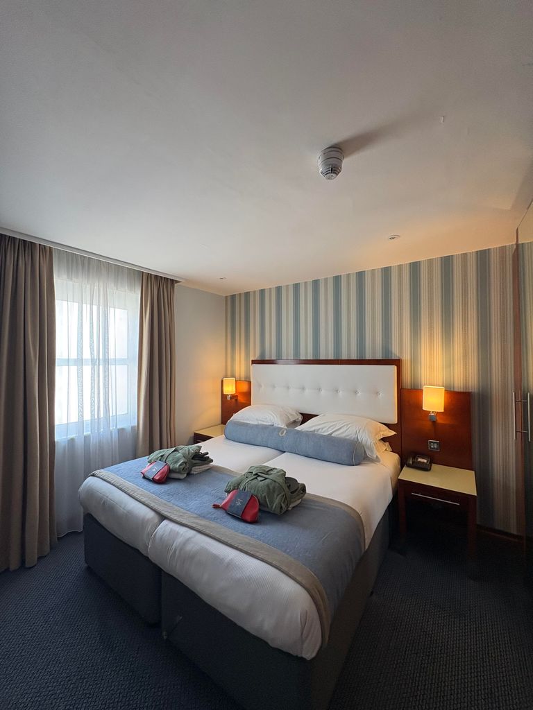 A double sized bed with two robes on it 