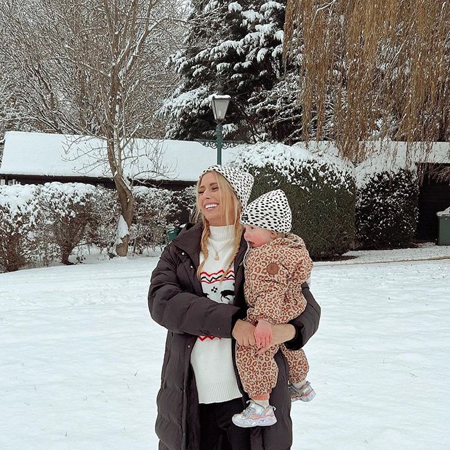 Stacey Solomon wrapped up warm whilst holding daughter Rose out in the snow