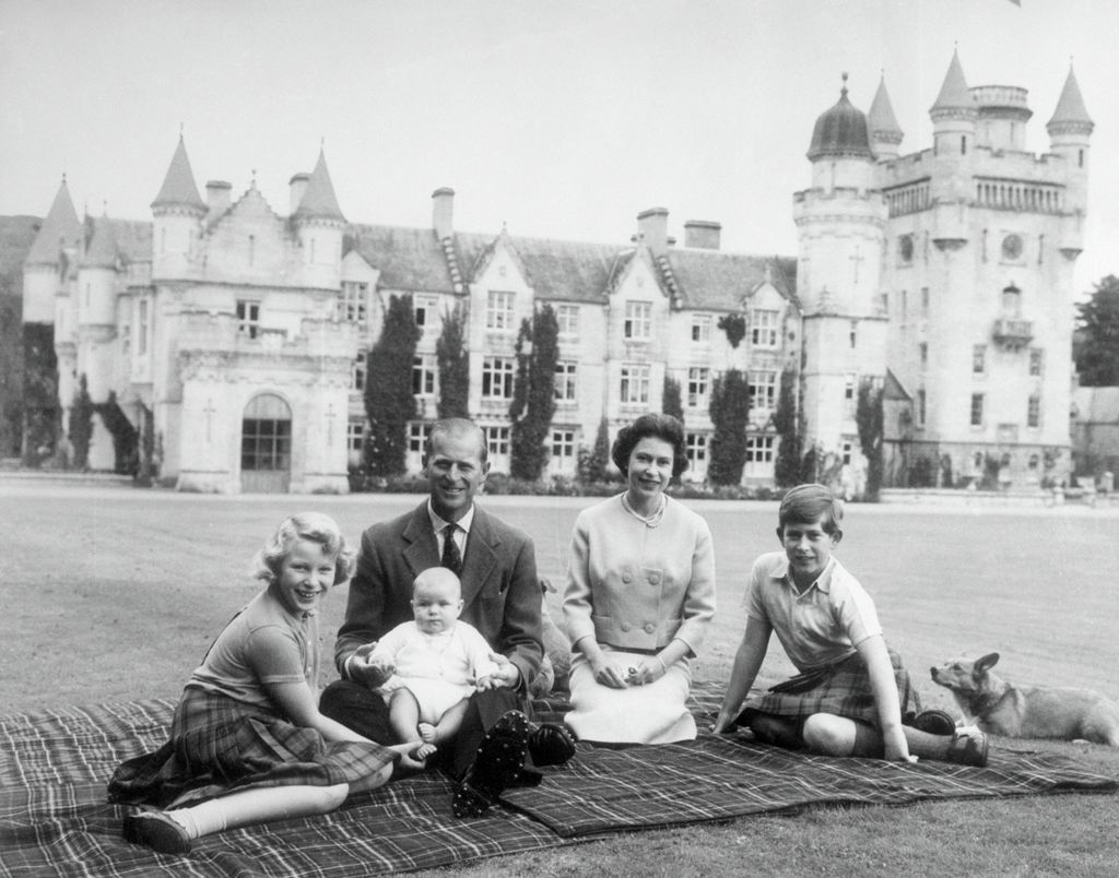 A black-and-white photograph the Queen and Prince Philip with a corgi and a young Princess Anne, Prince Andrew and King Charles
