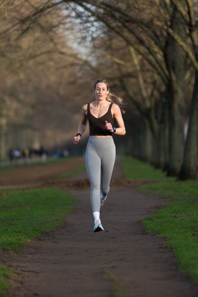 Woman running in grey leggings in the forest