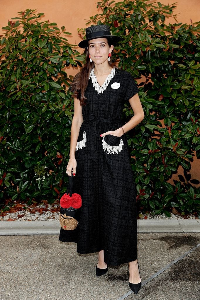 Natalie Salmon in a black textured fringe-trim dress with a boater hat and straw novelty bag at Royal Ascot.