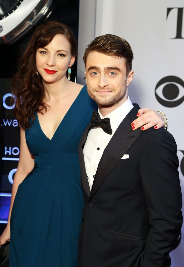 Daniel Radcliffe in a tuxedo and Erin Darke in a blue dress with red lipstick