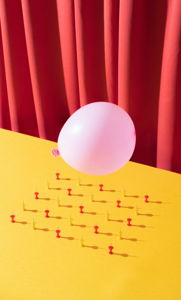 A pink balloon hovering over pins to depict a 'sinker'
