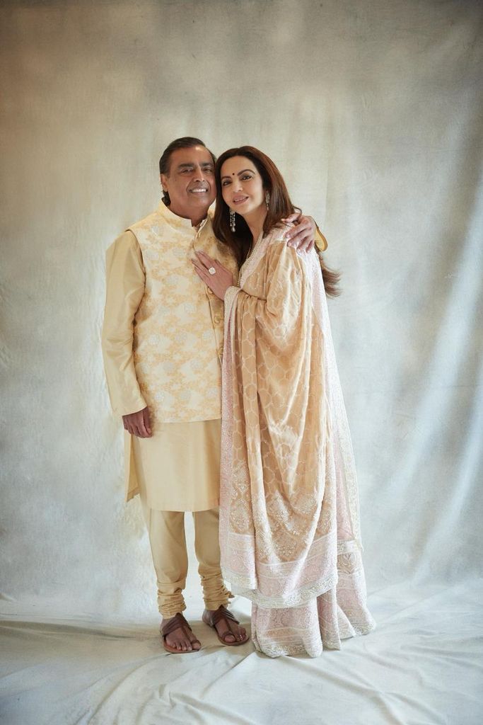 The parents of the groom smiling in neutral traditional Indian clothes