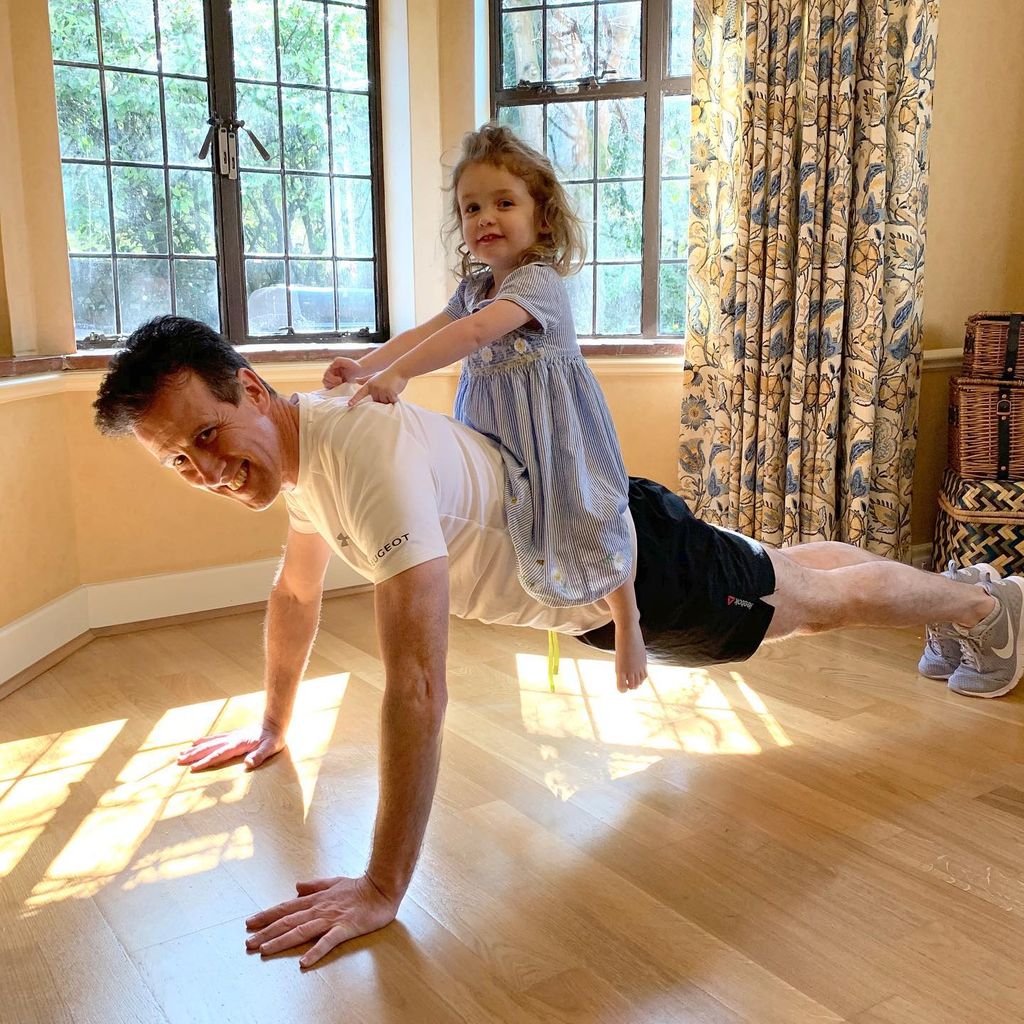 anton doing push up with young daughter on his back