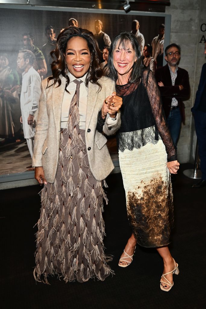 Oprah Winfrey with Prof Gill Foster in feathered skirt and blazer