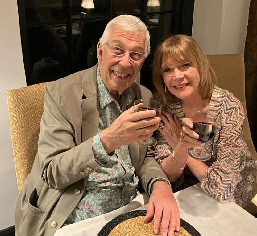 Jeffrey Holland et Judy Buxton avec des petits verres de vin rouge dans un restaurant
