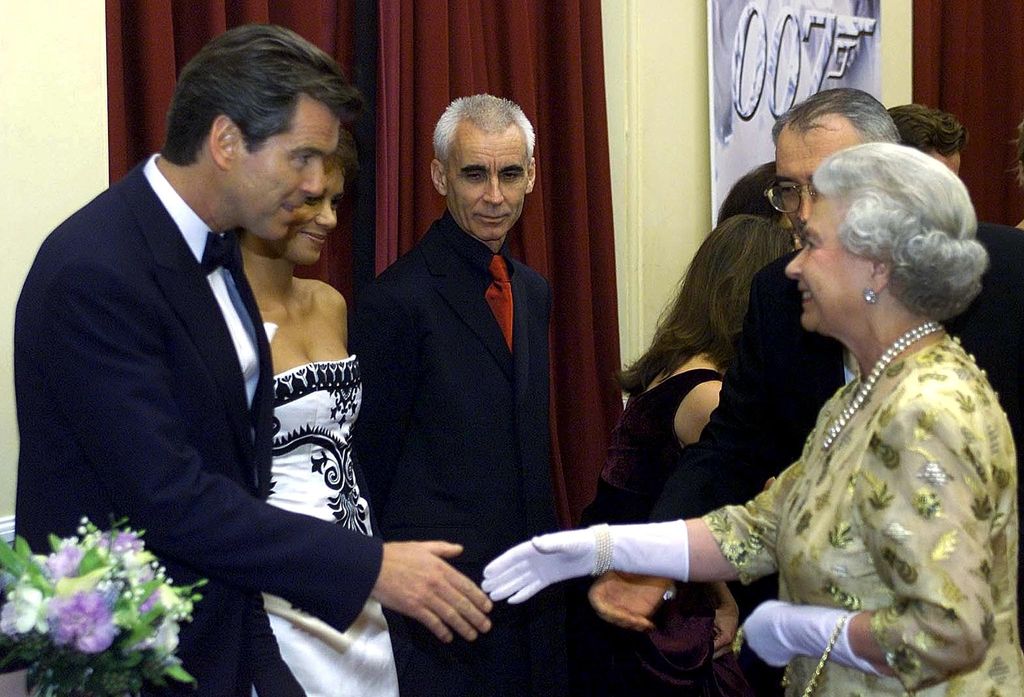The Queen wearing a yellow dress and white gloves greeting Pierce Brosnan at the World Premiere of the new James Bond film 'Die Another Day' in 2002