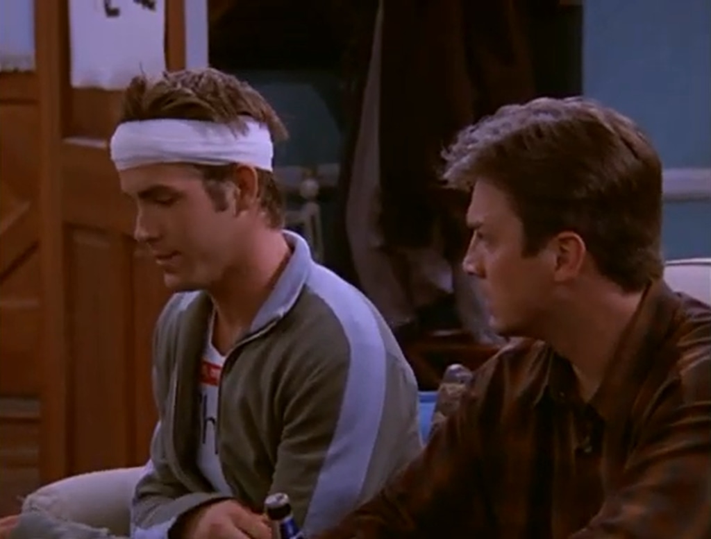 Nathan Fillion (R) and Ryan Reynolds sit on a sofa in still from Two Guys And A Girl