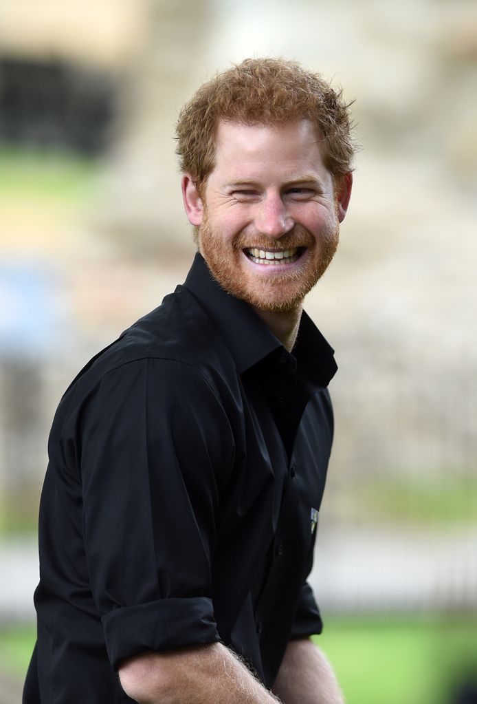 prince harry smiling in black shirt 