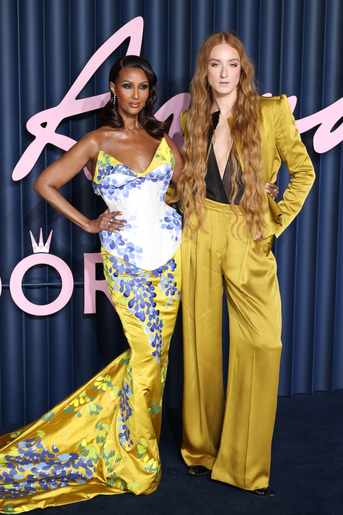 Iman in yellow dress beside harris reed in yellow suit