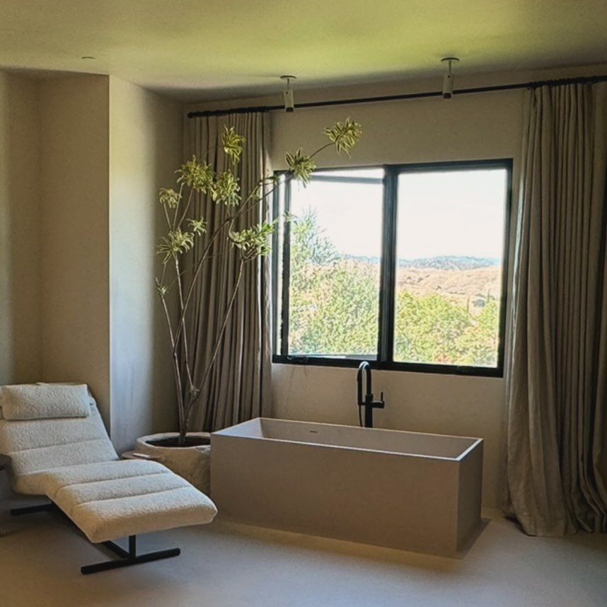 minimalist bathroom with a bright window over the bath tub 