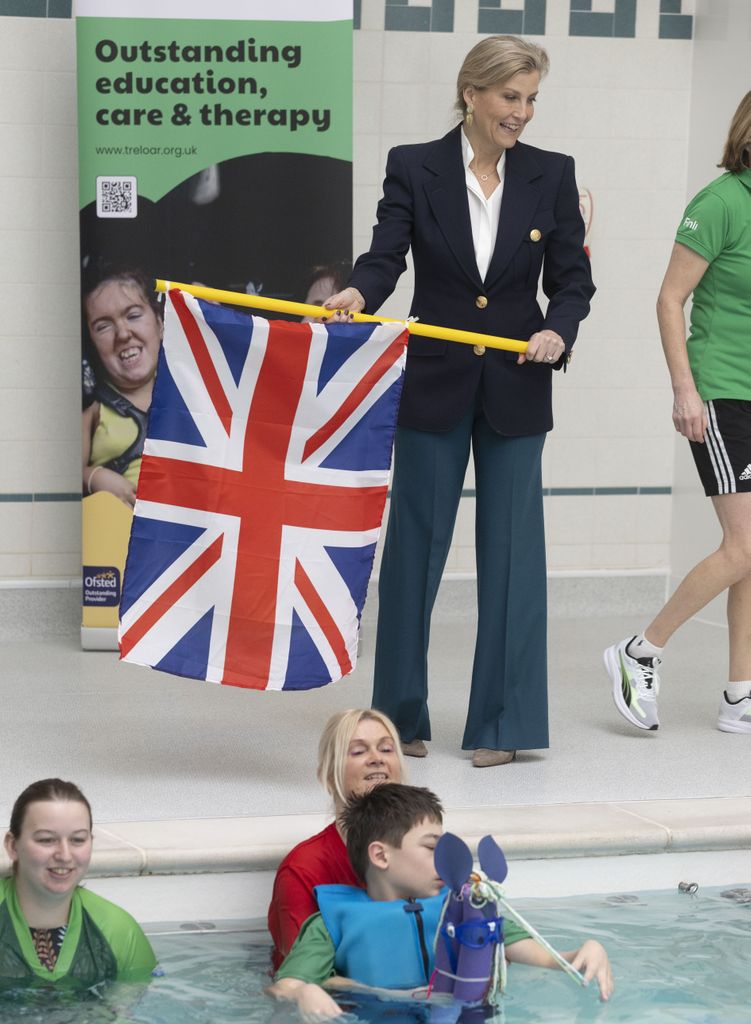 Sophie memegang bendera union jack di tepi kolam renang