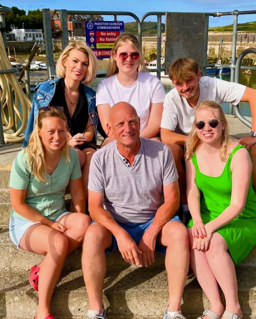 Steve Fletcher and his family sitting on the side of a dock