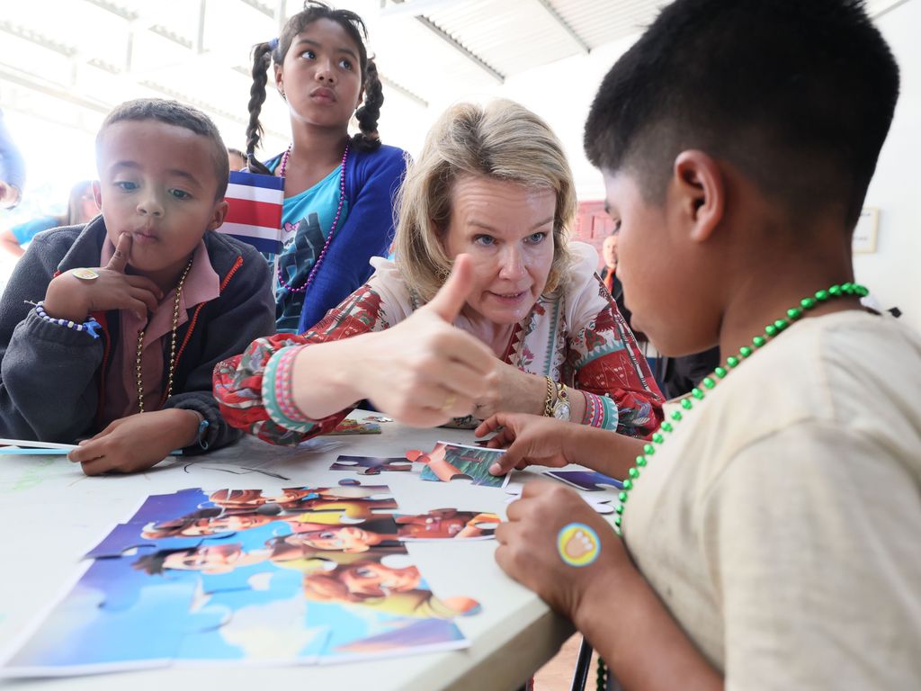 Queen Mathilde giving a 'thumbs up' gesture to a child