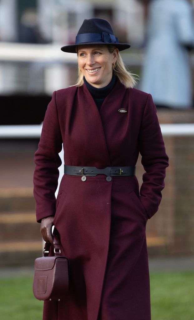 Zara Tindall walking in a maroon coat