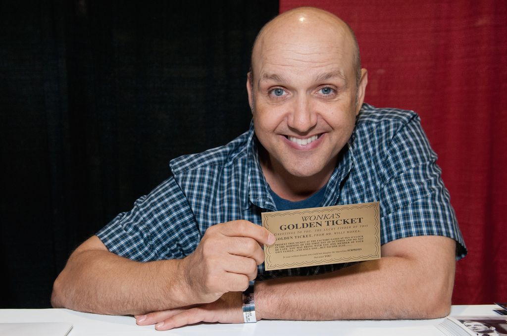 Paris Themmen at a desk holding a 'Golden Ticket'