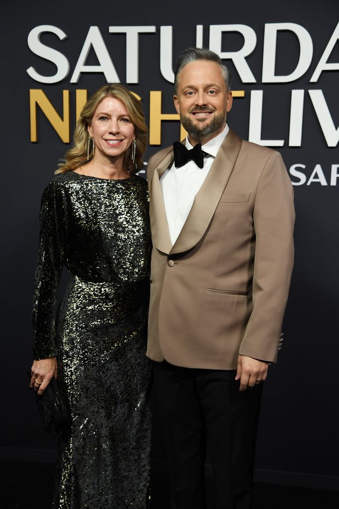 Laura Bargatze in green sparkly dress and Nate Bargatze in beige blazer and black bow tie